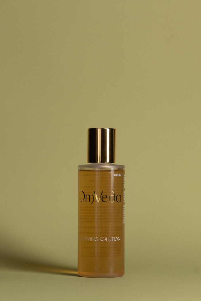 OmVeda clarifying solution 100ml amber bottle with gold cap, front label visible
