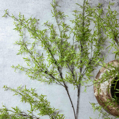 Artificial greenery branches on a textured surface