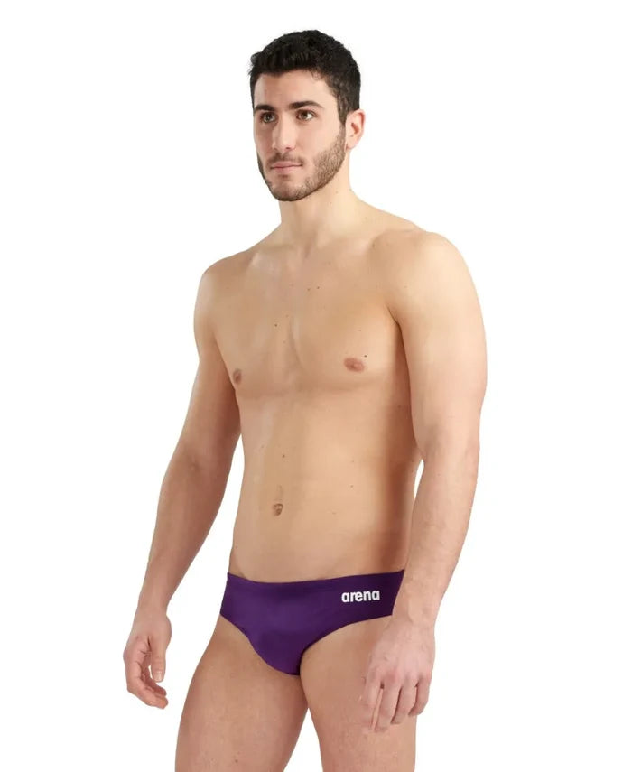 Arena men's solid team swim briefs in plum and white with a snug fit and quick-drying fabric, designed for competitive swimming.