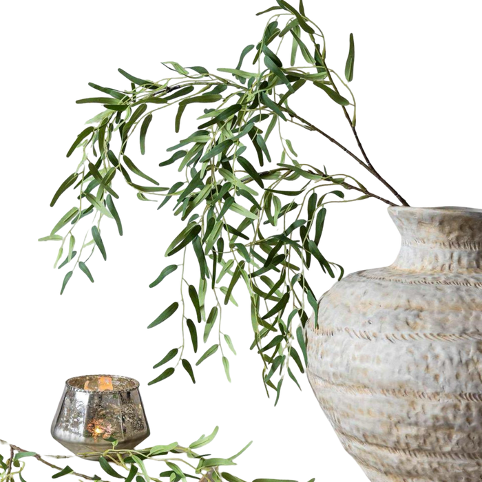 Decorative vase with green leaves and a candle on a white background