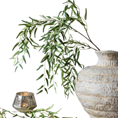 Decorative vase with green leaves and a candle on a white background