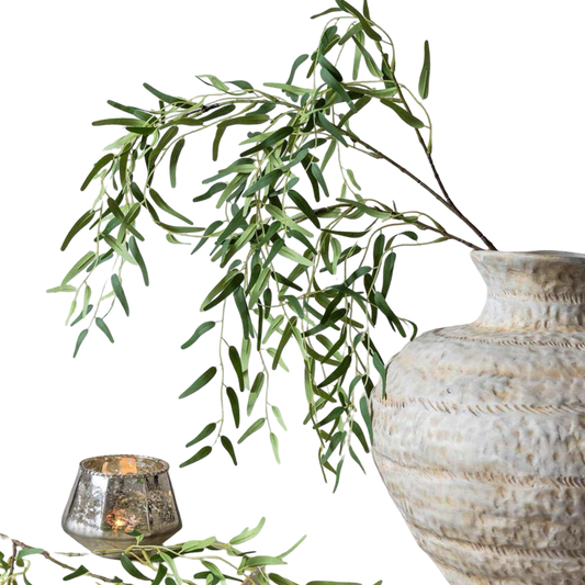Decorative vase with green leaves and a candle on a white background