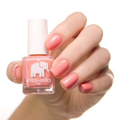 Cotton Candy soft peachy pink nail polish manicure on a light skin tone with the bottle