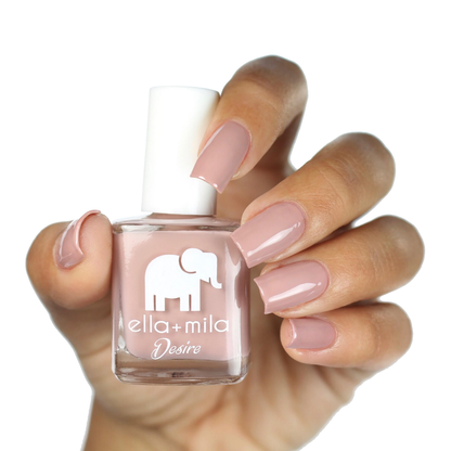 Desert Suede warm nude brown nail polish on a medium skin tone, hand holding the bottle