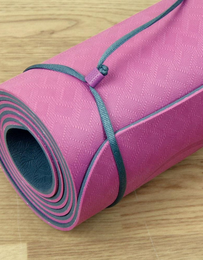 Rolled up pink Fitness Mad Evolution yoga mat with textured surface and gray trim
