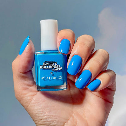 Gabby's Dollhouse sky blue nail polish manicure on a medium skin tone, holding the bottle