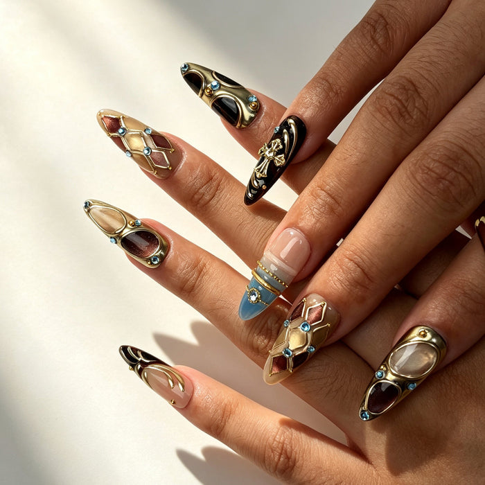 Close‑up handmade press‑on nails, gold metal‑relief cross ornament sparkling cyan rhinestone manicure