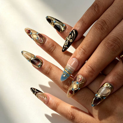 Close‑up handmade press‑on nails, gold metal‑relief cross ornament sparkling cyan rhinestone manicure