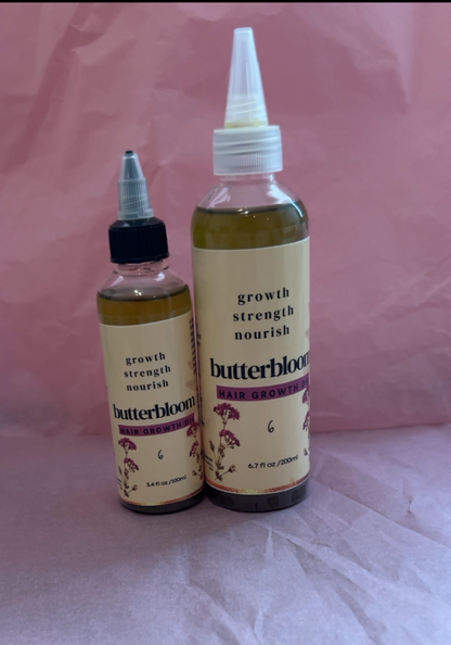 Bottle of butterbloom Hair Growth Oil infused with 21 herbs, showing the herbal-infused oil in a clear glass container.