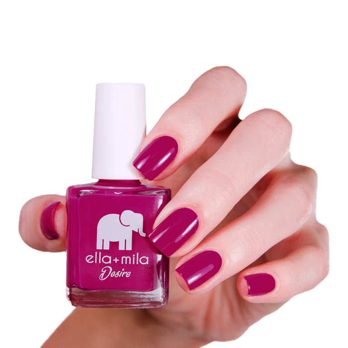 Heartbreaker dark hot pink nail polish manicure on a light skin tone, holding the bottle
