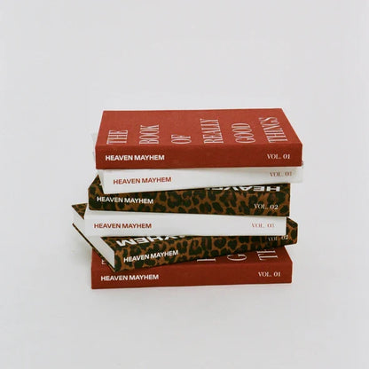 Stack of books titled 'Heaven Mayhem' on a white background