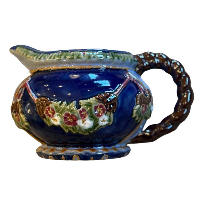 Decorative ceramic gravy boat with floral patterns on a white background