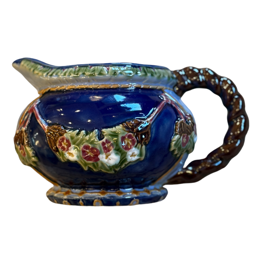 Decorative ceramic gravy boat with floral patterns on a white background