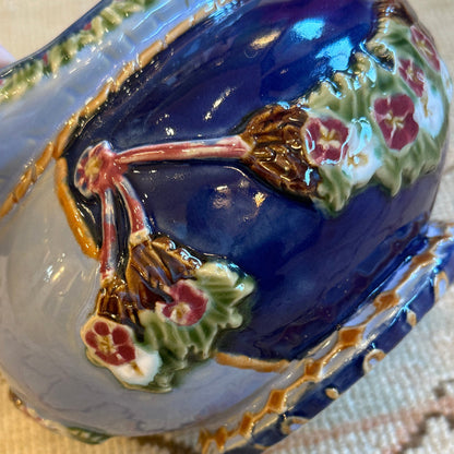 Decorative egg-shaped box with floral designs on a textured surface