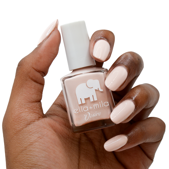 Light to the Touch neutral nude nail polish on a deep skin tone, hand holding the bottle