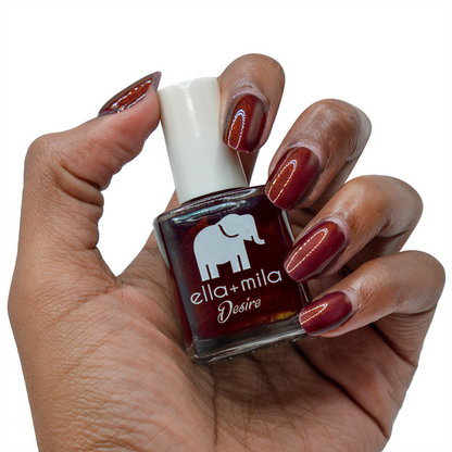 Lip Stain burgundy nail polish on a deep skin tone, hand holding the bottle