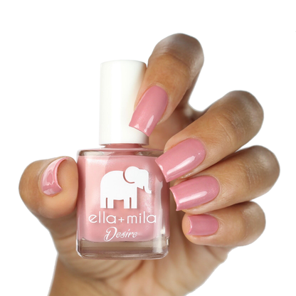 Luminous mauve pink shimmer nail polish on a medium skin tone, hand holding the bottle