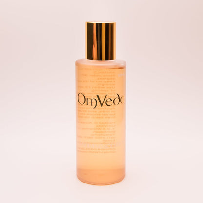 OmVeda clarifying solution 100ml translucent amber bottle with gold cap, front view