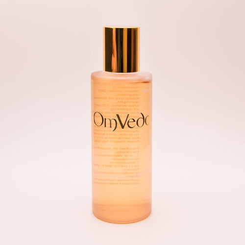 OmVeda clarifying solution 100ml translucent amber bottle with gold cap, front view