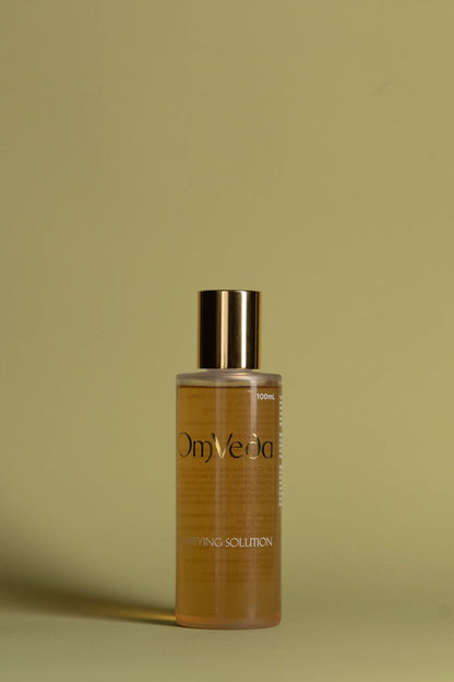 OmVeda clarifying solution 100ml amber bottle with gold cap, front label visible