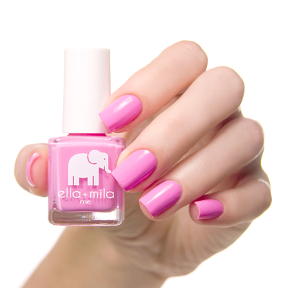 Pinkterest pink nail polish on a medium skin tone, hand holding the bottle