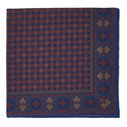 A folded burgundy and navy geometric patterned silk pocket square.