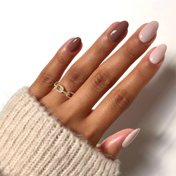 Stonehearted grey and mauve mix-and-match manicure on a medium skin tone with a gold ring