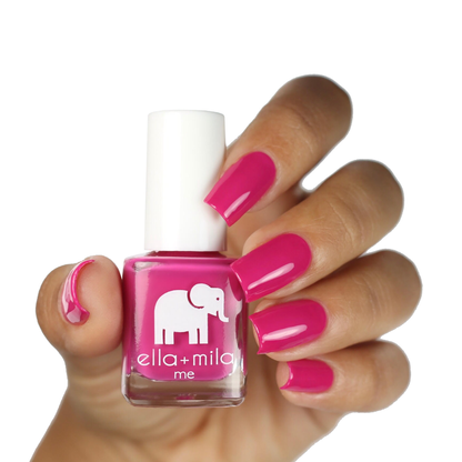 Sweet Tart hot pink nail polish on a medium skin tone, hand holding the bottle