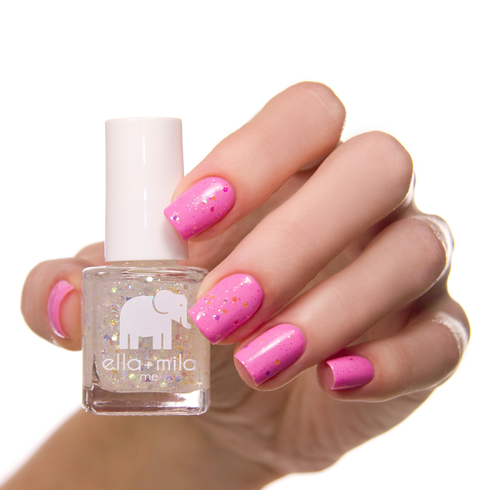 Twinkle Twinkle glitter accent nail over a hot pink manicure, holding the bottle