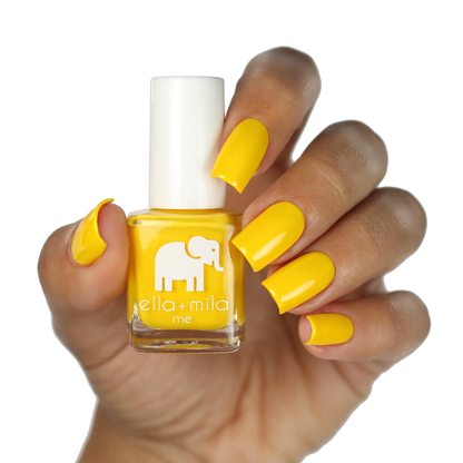 Wheels on the Bus yellow nail polish on a deep skin tone, hand holding the bottle